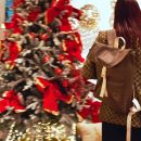Visitatrice con una stella di Natale davanti allo stand