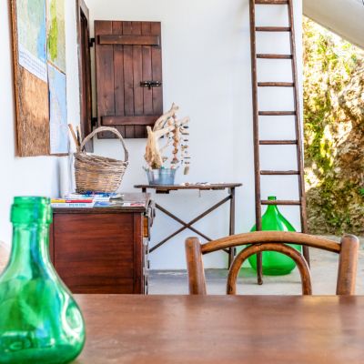 Terrazza arredata con tavolo, sedie e damigiana verde