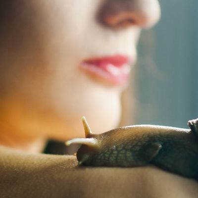 Donna con due grandi chiocciole appoggiate sulla spalla