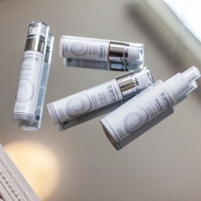 Flaconi della linea Biomyskin riflessi su una superficie