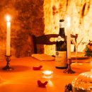 Tavolo nella neviera con bottiglia di vino Emidio Pepe, calici e fiori