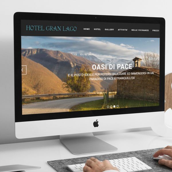 ingegnere che guarda sull'iMac la home page del sito web del Hotel Gran Lago di L'Aquila creato da Wainet Web Agency Teramo