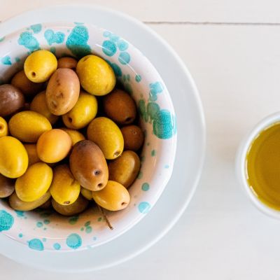 Piatto di olive con una ciotola di olio extravergine