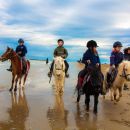 Gruppo di cavalieri Team Horse riunito in riva al mare