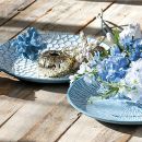 Tavola rustica con piatti blu, ortensie e decorazioni marine