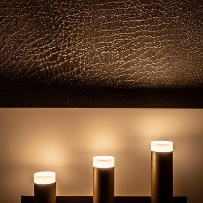 Testiera scura e punti luce della camera nella suite Ortensia