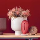 Brocca bianca con fiori rosa su sfondo rosso
