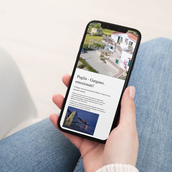 mano con Iphone che mostra il sito web in modalità mobile responsive della Villa Nettuno di Vieste