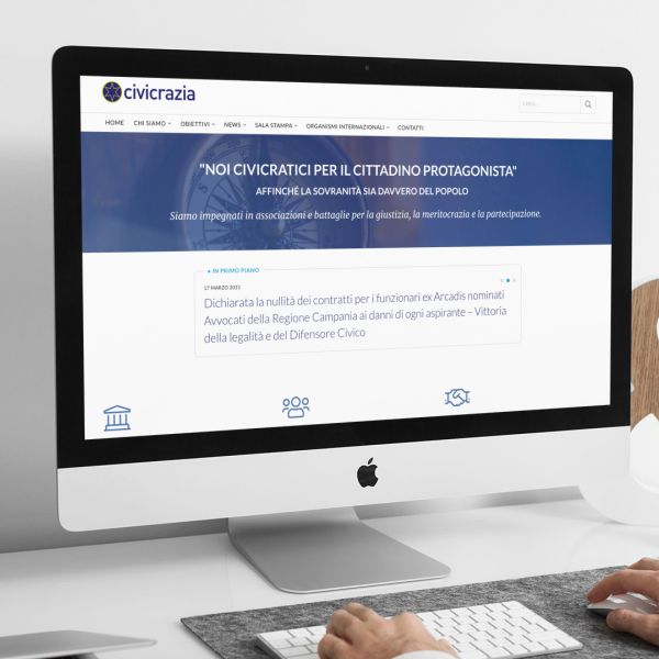 ingegnere che guarda sull'iMac la home page del sito web di Civicrazia creato da Wainet Web Agency