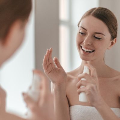 Donna sorridente mostra un flacone di siero viso Biomyskin