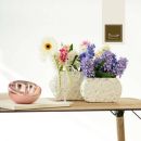 Mensola con vasi chiari e bouquet di fiori colorati