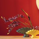 Ramo di orchidee viola in una coppa su sfondo rosso
