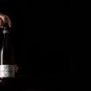 Mani ragazzo reggono una bottiglia di Trebbiano D'Abruzzo Tenuta Trium Notaresco Teramo Abruzzo