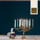 Candelabro dorato con candele bianche su sfondo blu