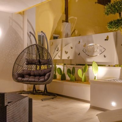 Patio notturno della suite Tulipano con poltrona sospesa e parete illuminata