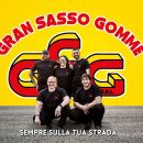 Squadra Gran Sasso Gomme davanti al grande logo aziendale