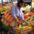 Donna con borsa colorata mentre fa la spesa tra la frutta