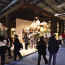 Vista ampia della fiera dell'arredo con visitatori e stand Bruco