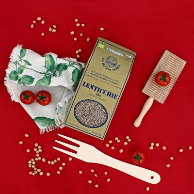 Confezione di lenticchie abruzzesi in una composizione still life su sfondo rosso