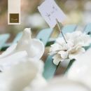 Tavola bianca con fiori, segnaposto e piccoli oggetti in ceramica