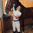 Donna mentre abbraccia un cavallo nel box del Maneggio Team Horse