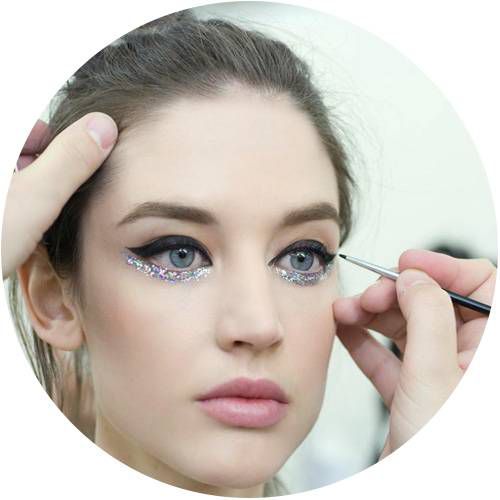 Mano di truccatore applica eyeliner a modella